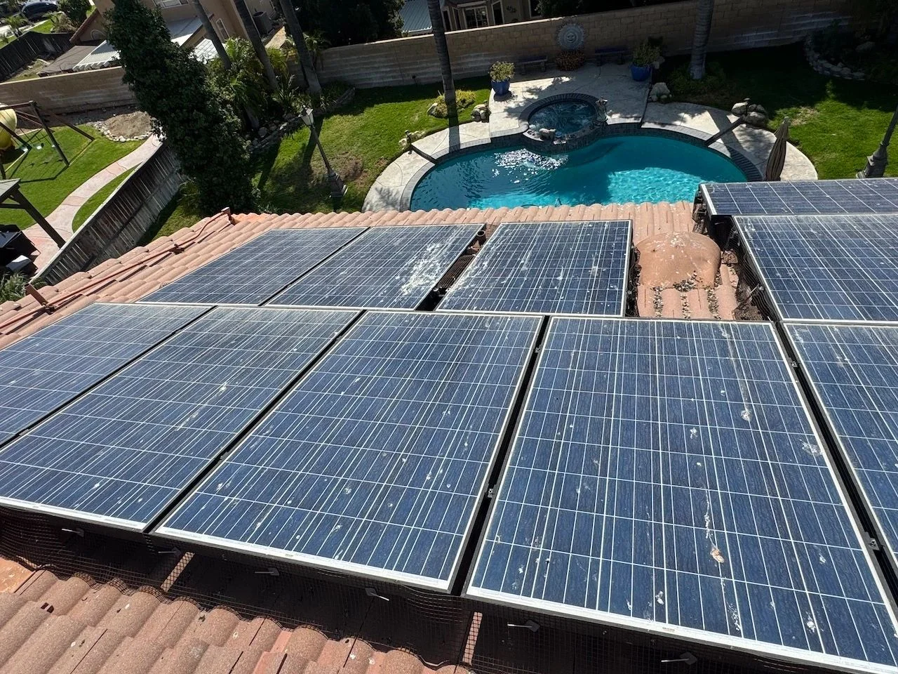 Rooftop solar panels above a backyard — original business project photo